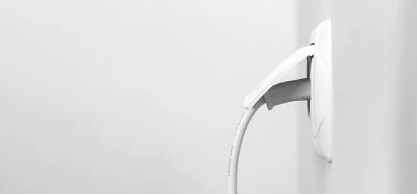 Kabel Ditancapkan Pada Outlet Listrik Putih Pada Dinding Putih Interior — Stok Foto