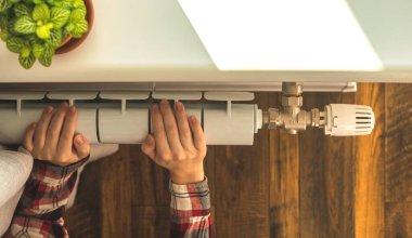 Kadın eli ve ısıtma radyatörü modern iç mimariye sahip bir dairede.