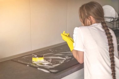 Genç kız mutfağı temizlerken dinleniyor, temizlik ve temizlik konsepti, elektrikli tencere bakımı