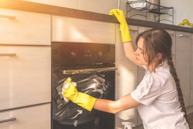 Modern mutfak içinde fırın temizleyen kadın, ev hanımı konsepti, genç kız apartman bakımı 