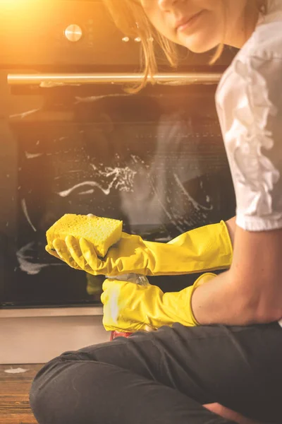 Young girl learns to clean the house and cleaning the kitchen, rubber gloves with the rag sponge