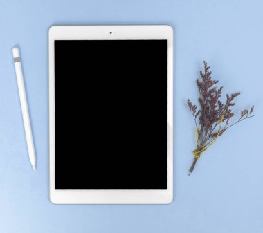 Tablet pc, stilus ve çiçeklenmiş çiçekli minimalist çalışma alanı kavramı, kopyalama alanı 