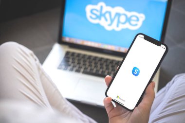 Kharkov, Ukrayna - 12 Ağustos 2021: Skype uygulaması. Skype uygulaması olan akıllı telefon kullanan bir kadın. Marka logosu