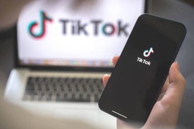 Kharkov, Ukrayna - 12 Ağustos 2021: Tiktok sosyal medya uygulaması. Tiktok uygulaması olan akıllı telefon kullanan bir kadın. Marka logosu