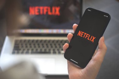 Kharkov, Ukrayna - 12 Ağustos 2021: Netlix uygulaması. Netflix yayın uygulaması olan akıllı telefon kullanan bir kadın. Marka logosu 