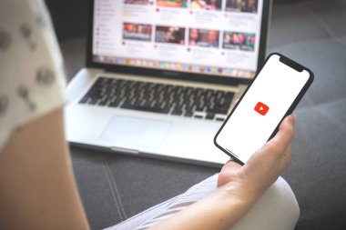 Kharkov, Ukrayna - 12 Ağustos 2021: Youtube uygulaması. Çevrimiçi youtube uygulaması olan akıllı telefon kullanan bir kadın. Marka logosu 