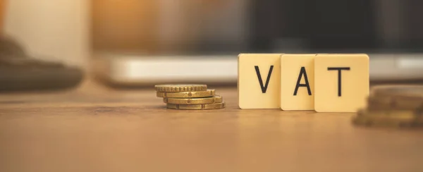 Banner VAT value added tax. Business finance concept with coins and laptop on desktop, copy space