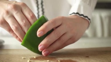 Evde doğal ürünle yemek pişirme kavramı. Ahşap kesim tahtasında tatlı biber sebzeli şef, yavaş çekim yakın çekim video.