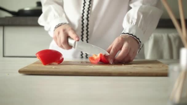 シェフによる木製のまな板に赤ピーマンをスライス 女性はパプリカの野菜を切っている 健康食と食事のコンセプトビデオ — ストック動画