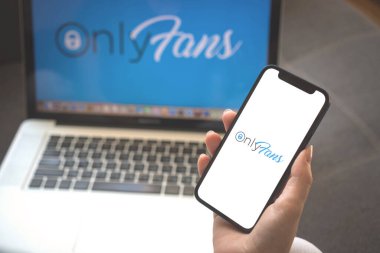 Kharkov, Ukrayna - 23 Ağustos 2021: Onlyfan uygulama logosu, cep telefonu ekranı. Onlyfan uygulaması kullanan kadın