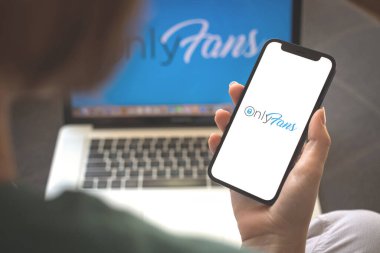Kharkov, Ukrayna - 23 Ağustos 2021: Onlyfan uygulamasını kullanan kadın. Cep telefonu ekranında sadece hayranlar uygulama logosu