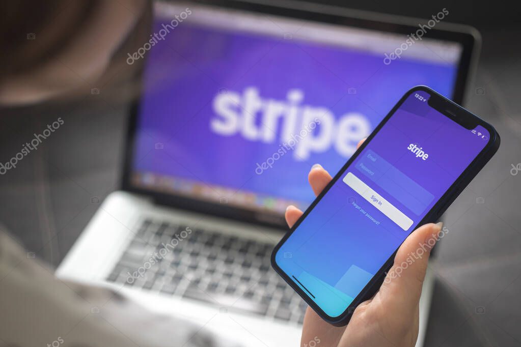 Kharkov, Ukraine - August 25, 2021: Woman using Stripe application and holding smartphone, closeup