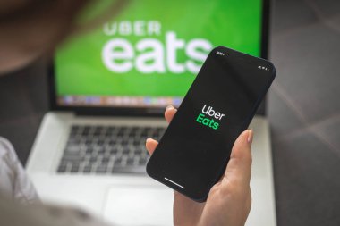 Kharkov, Ukrayna - 25 Ağustos 2021: Uber Eats uygulaması kullanan ve elinde akıllı telefon tutan kadın, kapat