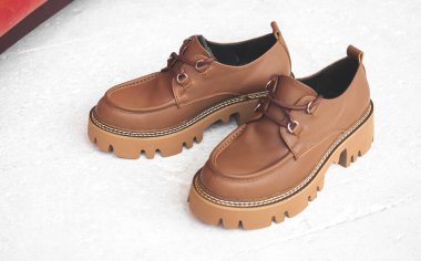 Stüdyoda deri kadın ayakkabıları var. Beton zemin manzaralı. 