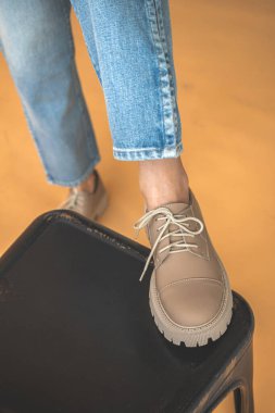 Kot elbiseli kadın ayaklarında şık spor ayakkabılar. Yaşam tarzı ve moda tasarım arkaplanı