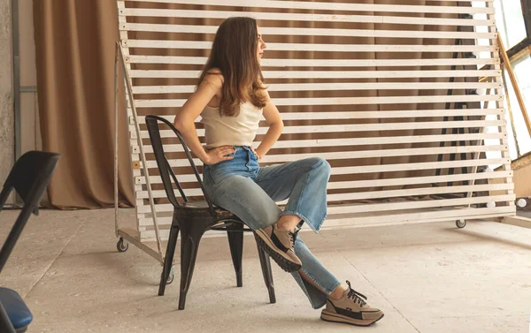 Mujer Joven Ropa Casual Posando Silla Interior Del Estudio Urbano —  Fotos de Stock