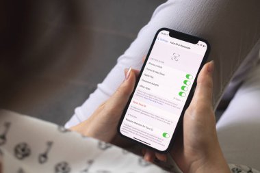 Kharkov, Ukrayna - 25 Ağustos 2021: Kadın Apple iPhone ekranında Yüz Kimliği ayarlarını açıyor