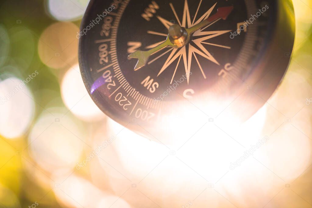 Travel orientation, adventure navigation with the compass in the woods or forest background, close-up view