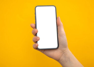Sarı arkaplanda cep telefonu modelleme ekranı olan el, boşluğu kopyala