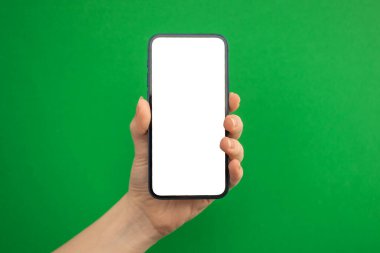 Yeşil arkaplanda cep telefonu modelleme ekranı olan el, boşluğu kopyala 