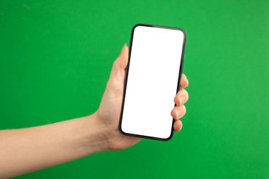 Yeşil arkaplanda boş beyaz ekranlı cep telefonu tutan kişi, boşluğu kopyala