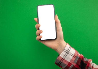 Yeşil arkaplanda cep telefonu modelleme ekranı tutan kadın, boşluğu kopyala