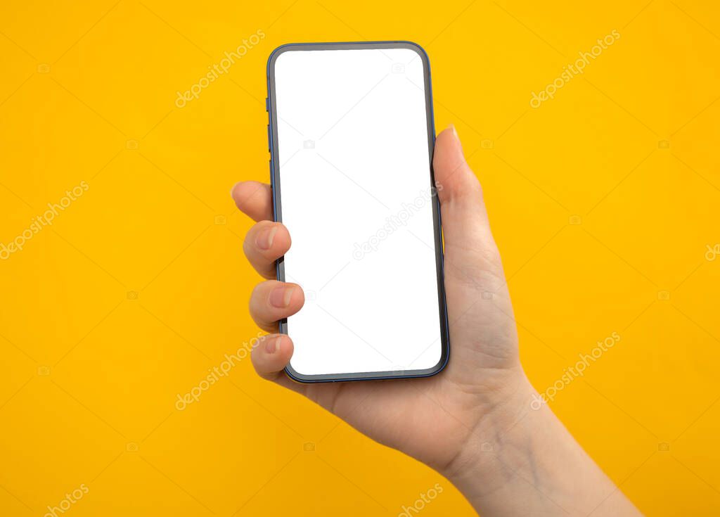 Hand with mobile phone mockup screen on a yellow background, copy space