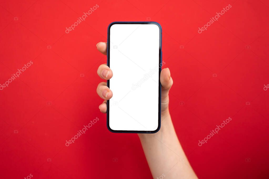 Mockup of mobile phone in hand on bright red colored background, copy space