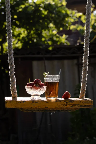 Cup of tea and wild strawberries on a wooden background — Stock Photo, Image