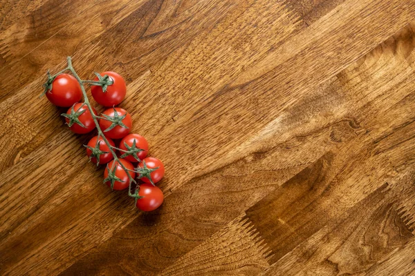 Background with red cherry tomatoes on the wooden table.