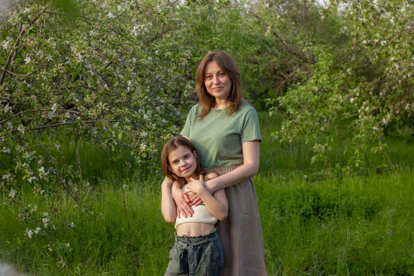 Belle ragazze che camminano all'aperto tra i meli in fiore. Fotografia Stock