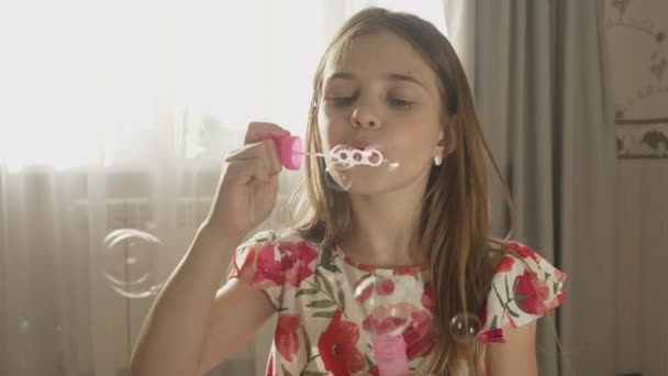 在客厅里开心地笑着 吹肥皂泡 快乐的小女孩在家里玩得很开心 — 图库视频影像