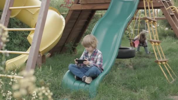 Criança Usando Telefone Inteligente Line Playground Rapaz Brincar Dispositivos Portáteis — Vídeo de Stock
