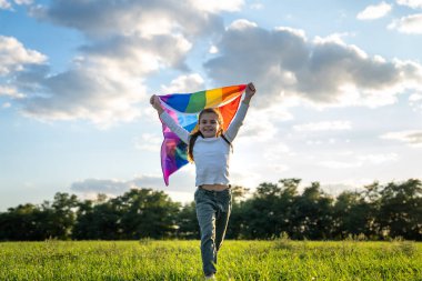 Aşkın sembolü, özgürlük ya da LGBT gurur konsepti. Gökkuşağı bayrağını mavi arka planda tutan kız yazın açık havada. Özgürlük hakkı, eşitlik ve yasal evlilik gururu.