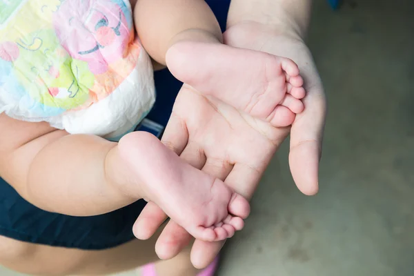 Baby feet in mother's hands. — Stock Photo, Image