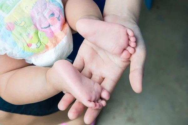 Baby feet in mother's hands. — Stock Photo, Image