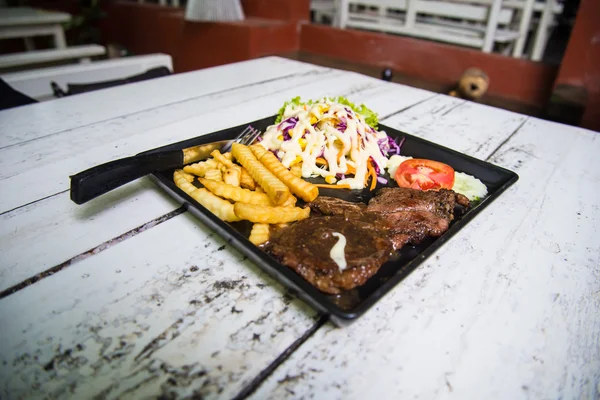 Steak babi dengan roti panggang di atas meja kayu . — Stok Foto