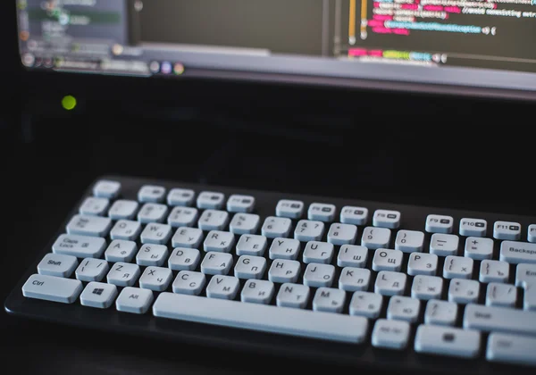 Teclado con teclas blancas delante del monitor — Foto de Stock