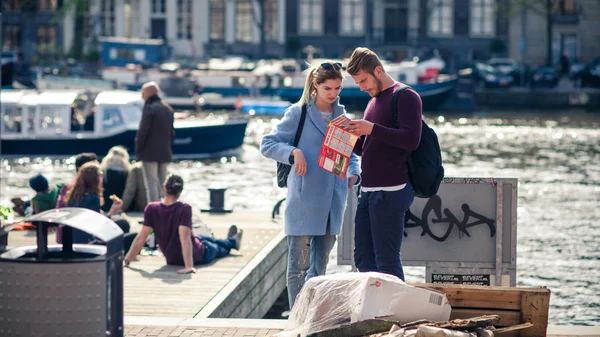 Touristen beobachten die Karte am Ufer des Kanals. — Stockfoto