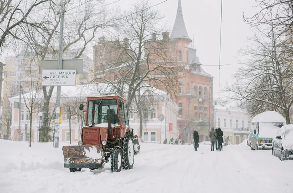 Trekker in de sneeuw op een straat schoonmaken — Stockfoto