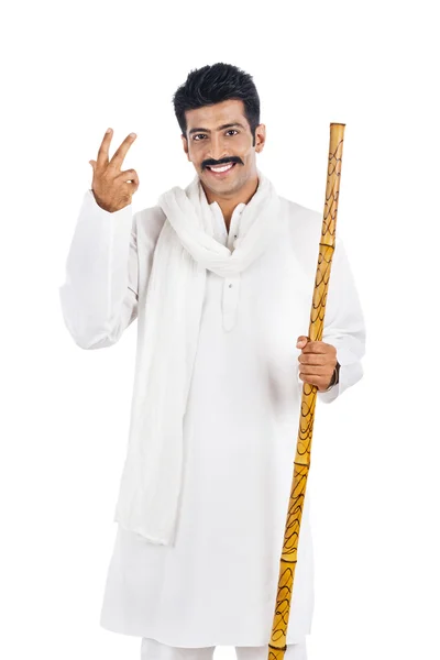 Portrait of a man holding a wooden staff and smiling — Stock Photo, Image