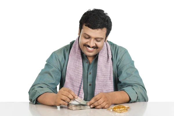 Smiling man counting money — Stock Photo, Image