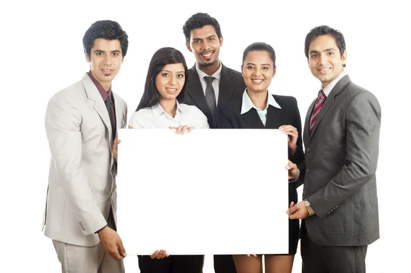 Portrait of business executives holding a placard and smiling — Stock Photo, Image