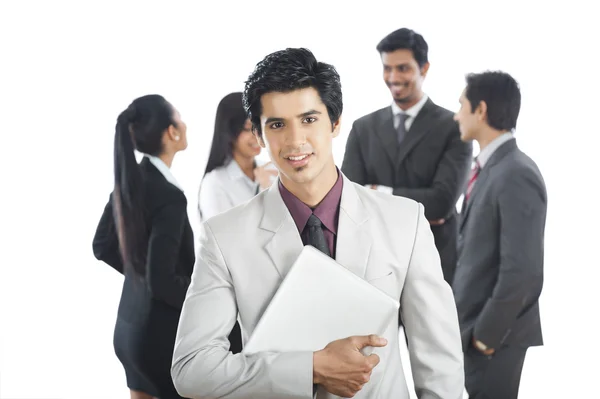 Porträtt av en affärsman leende med kollegorna i bac — Stockfoto