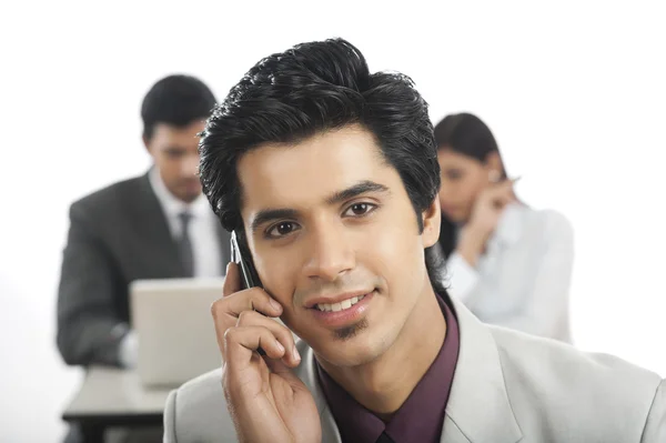 Portrait of a businessman talking on a mobile phone with his col — Stock Photo, Image