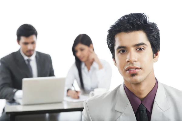 Portrait of a businessman with his colleagues in the background — Stock Photo, Image