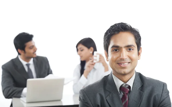 Portrait of a businessman smiling with his colleagues in the bac — Stock Photo, Image