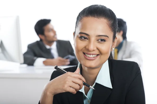 Empresária sorrindo em um escritório com seus colegas no — Fotografia de Stock