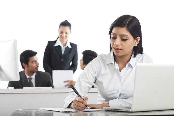 Businesswoman working in the office with her colleagues in the b — Stock Photo, Image