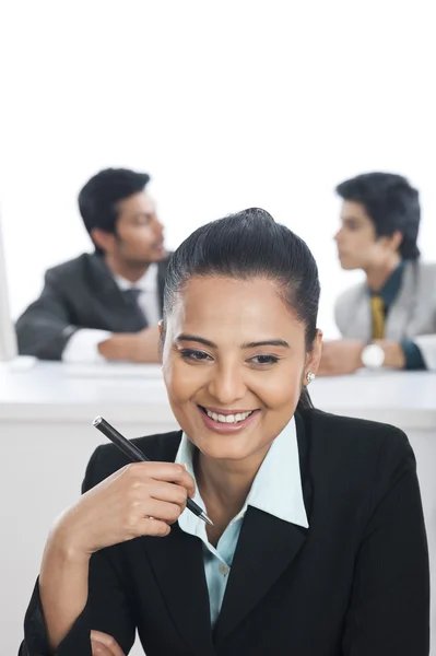 Üzletasszony a kollégáikkal egy irodában mosolyogva a — Stock Fotó